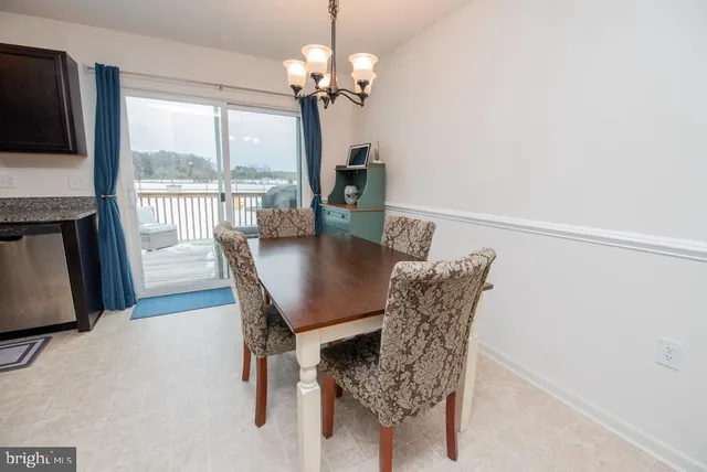 a dining room with furniture a chandelier and wooden floor