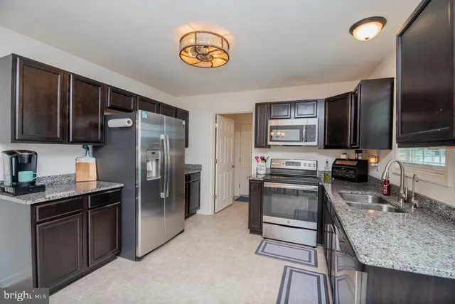 a kitchen with stainless steel appliances granite countertop a refrigerator stove and oven