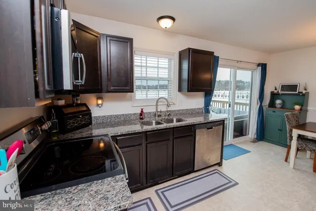 a kitchen with granite countertop a sink stove and cabinets