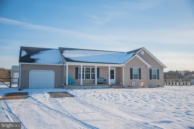 a front view of a house with a yard and potted plants