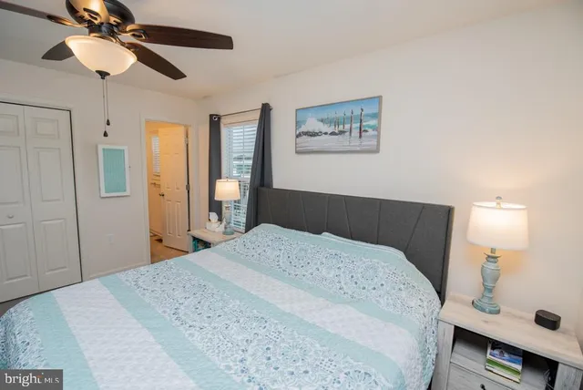 a bedroom with a bed a flat screen tv and a window