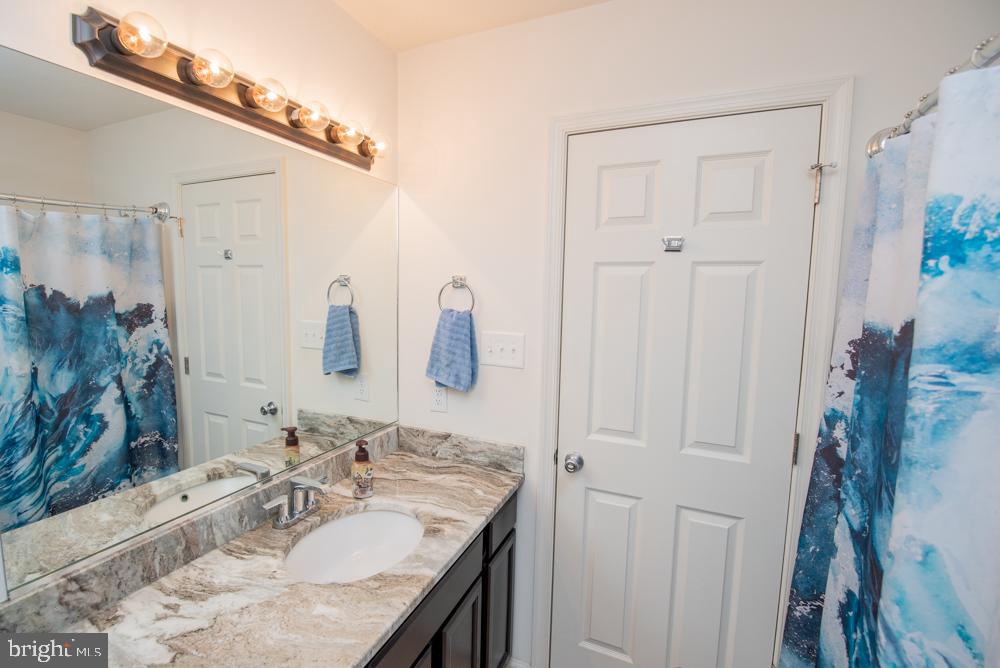 17180 Philips Hill Road Laurel, DE 19956 - Photo 38 of 65 a bathroom with a granite countertop sink a mirror and shower
