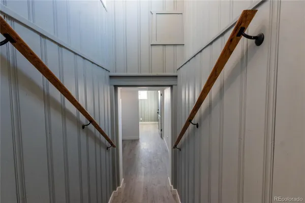 a view of staircase with lots of frames on wall and wooden floor