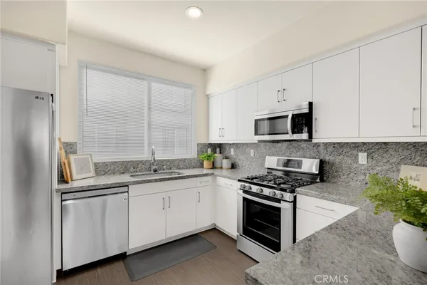 a kitchen with white cabinets and appliances
