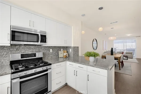 a kitchen with stainless steel appliances granite countertop a stove top oven microwave and cabinets