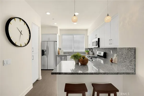 a kitchen with granite countertop a table chairs stove and cabinets
