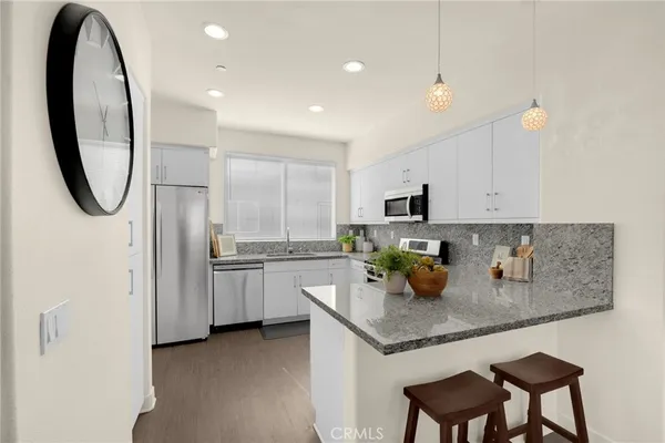 a kitchen with stainless steel appliances granite countertop a sink and a stove