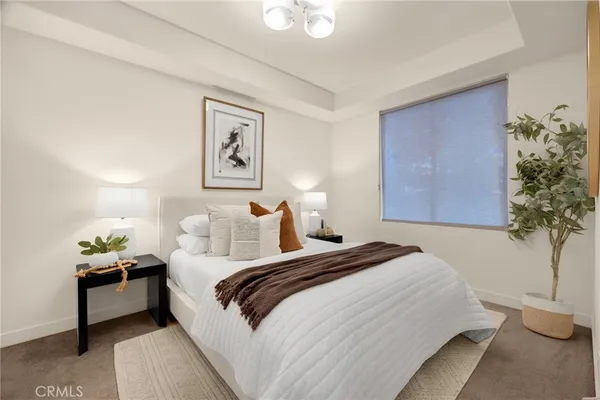 a bedroom with a bed and a potted plant