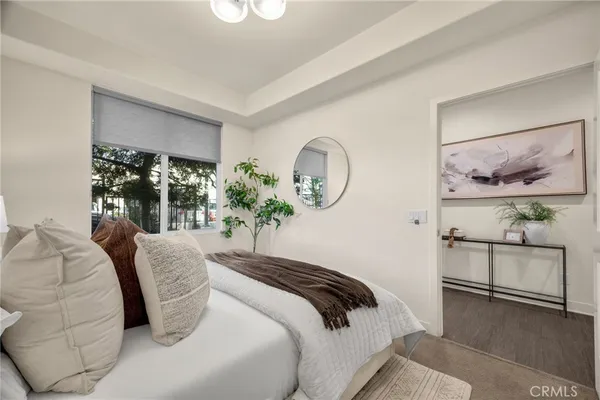a bedroom with a large bed and a potted plant