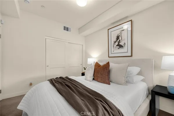 a bedroom with a bed and a painting on the wall