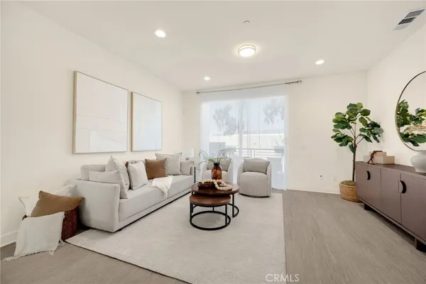 a living room with furniture white wall and a large window