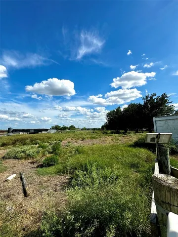 a view of a pathway both side of grassy field with shrub