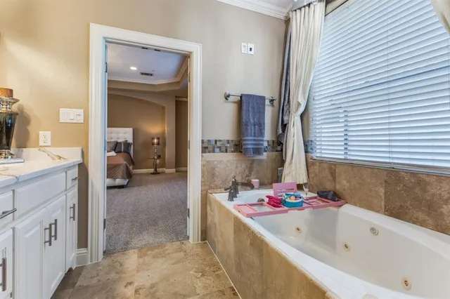 a bathroom with a tub sink and mirror
