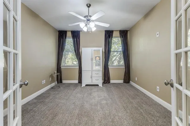 an empty room with kitchen view and wooden floor