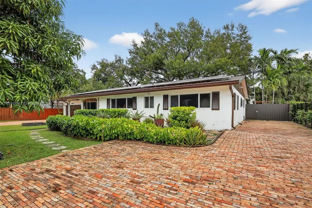 a view of a swimming pool with a large tree in front of it