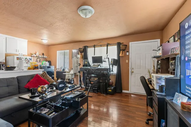 a living room with furniture a flat screen tv and a floor to ceiling window
