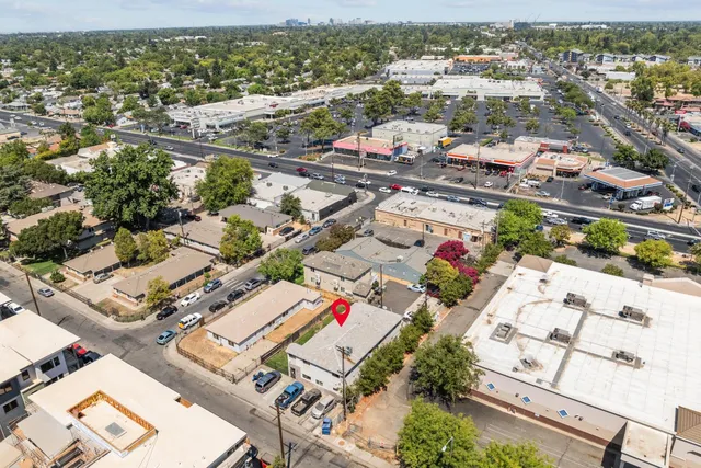 an aerial view of residential houses with outdoor space and parking