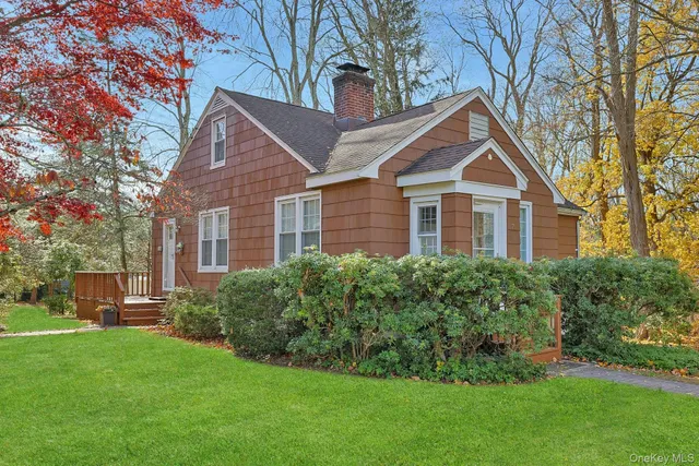 a front view of a house with a yard and trees