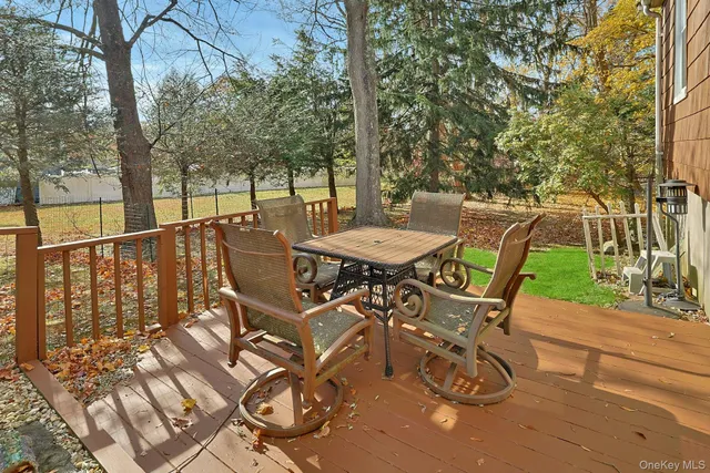 a view of a patio with table and chairs with wooden fence and floor