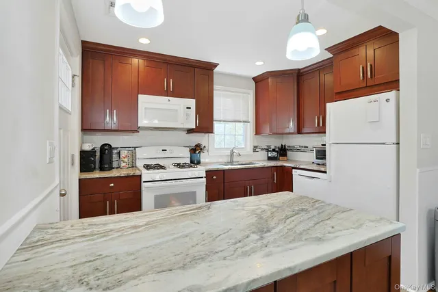 a kitchen with granite countertop a refrigerator stove top oven and sink
