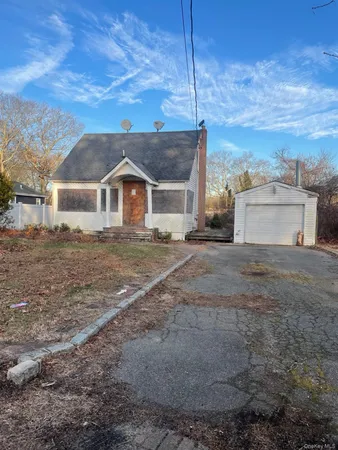 a view of a yard in front of a house with large windows