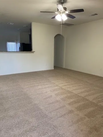 an empty room with a ceiling fan and a window