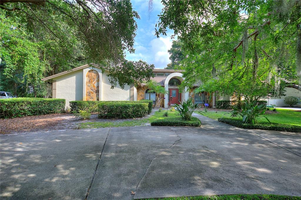 11809 Lake Butler Boulevard Windermere, FL 34786 - Photo 1 of 1 a front view of a house with a garden and plants