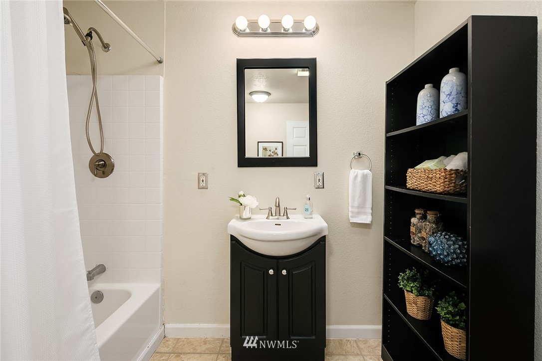 2613 Northeast 7th Street Renton, WA 98056 - Photo 17 of 23 a bathroom with a sink a mirror and shower