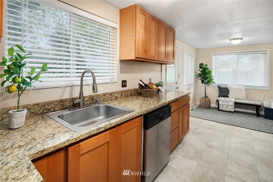 2613 Northeast 7th Street Renton, WA 98056 - Photo 9 of 23 a kitchen with granite countertop a sink and a white wooden cabinets