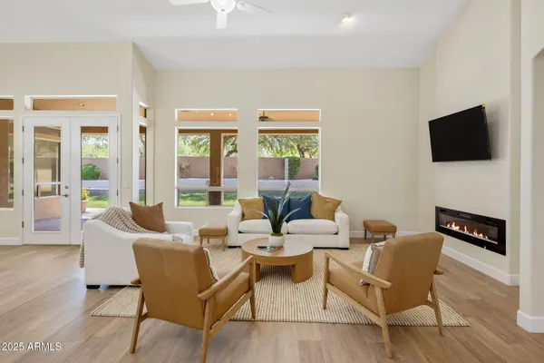 a living room with furniture a flat screen tv and a large window