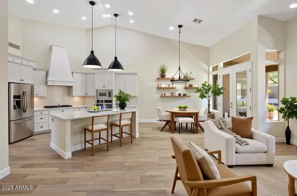 a kitchen with stainless steel appliances a dining table chairs stove a refrigerator and cabinets