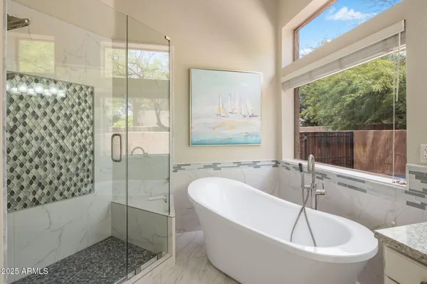 a bathroom with a tub sink and mirror