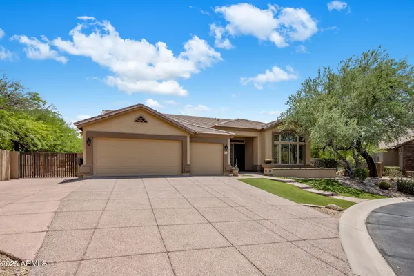 a front view of a house with a garden and trees