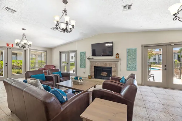 a living room with furniture a chandelier and a fireplace