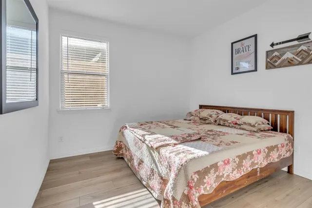 a large bed sitting in a bedroom next to a window
