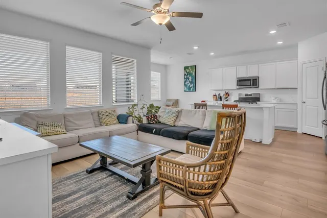 a living room with furniture a dining table and a chandelier