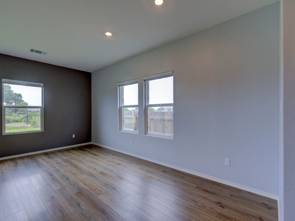 1716 Frontenac Street Leander, TX 78641 - Photo 15 of 34 an empty room with wooden floor and windows