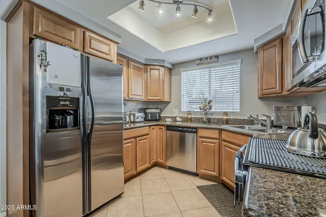 a kitchen with granite countertop a refrigerator and a sink