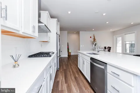 a view of a large kitchen with dining room wooden floor and windows