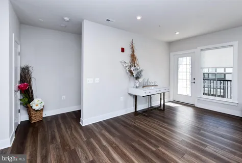 a kitchen with stainless steel appliances a table chairs refrigerator and wooden cabinets