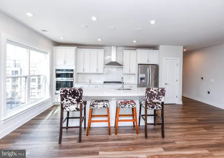 a view of a big room with wooden floor and windows