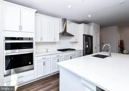 a view of empty room with wooden floor and windows