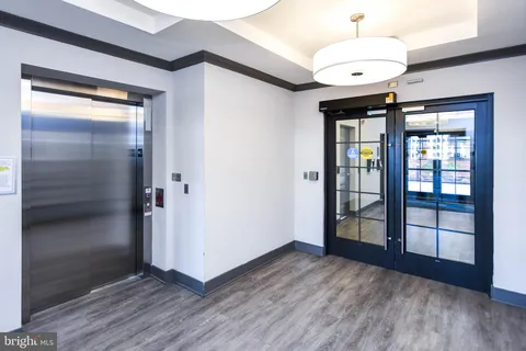 a view of an empty room with cabinet and wooden floor
