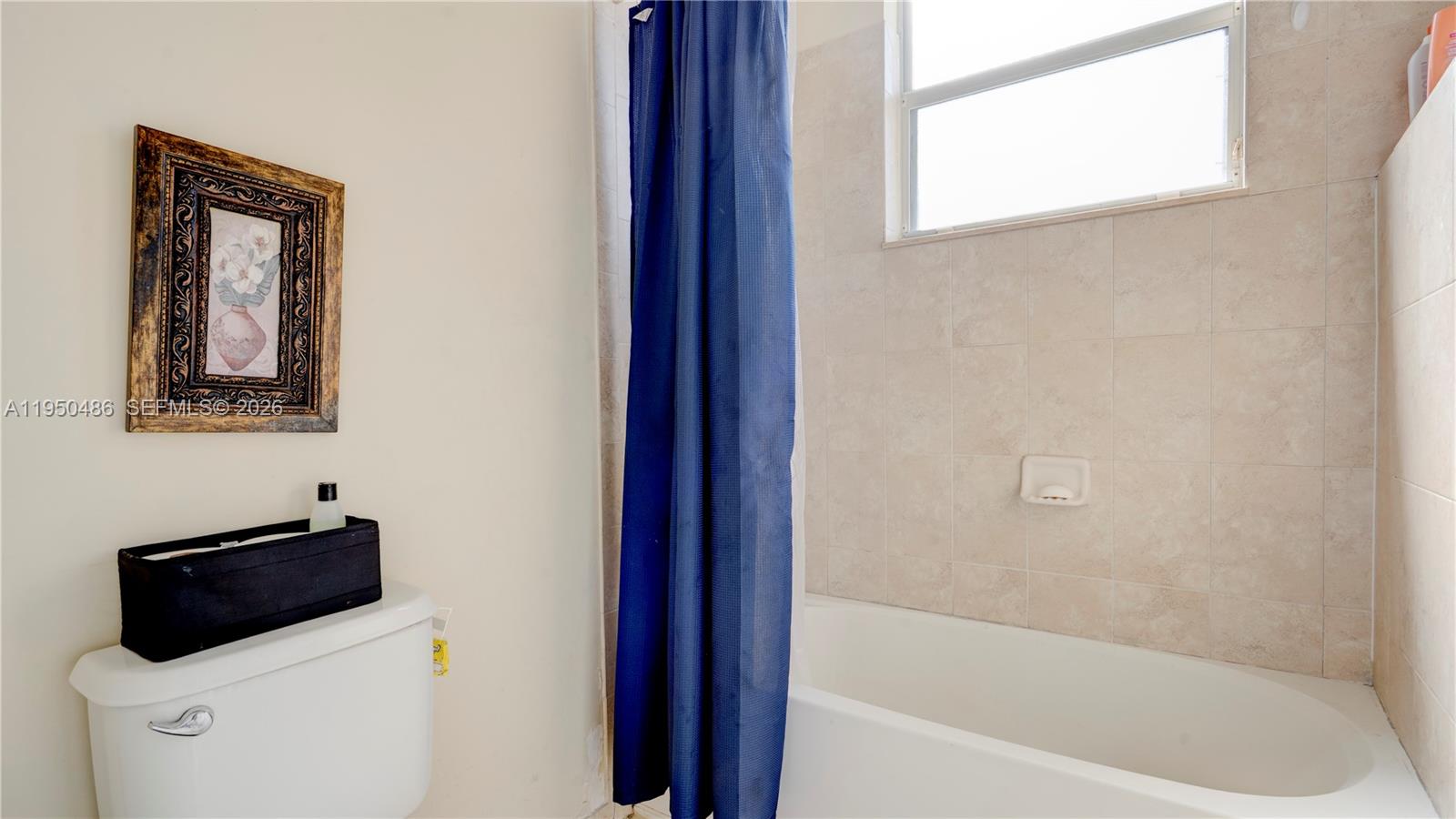 355 Northeast 31st Avenue Homestead, FL 33033 - Photo 31 of 62 a bathroom with a bathtub and a window