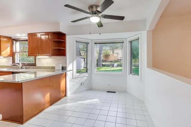 a large white kitchen with a large window cabinets and appliances
