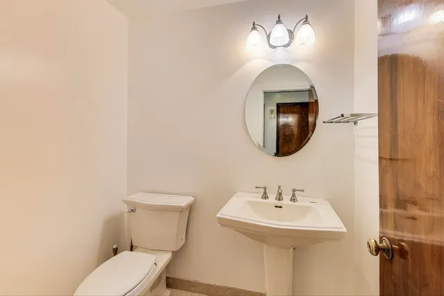 a bathroom with a toilet sink and mirror