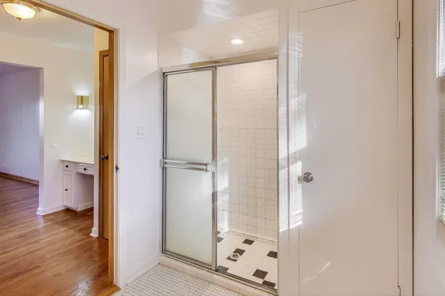 a bathroom with a shower and a glass door