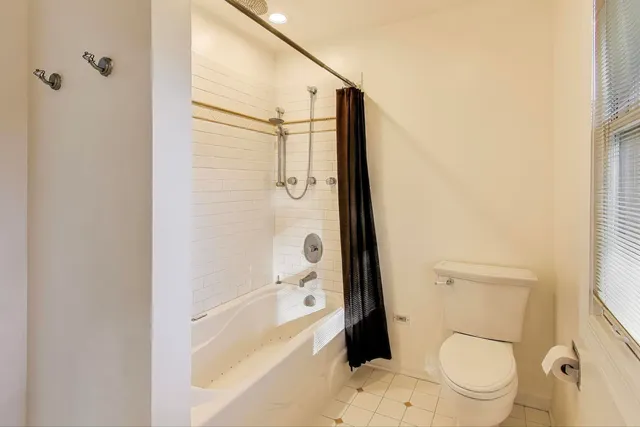 a bathroom with a granite countertop toilet a sink and shower