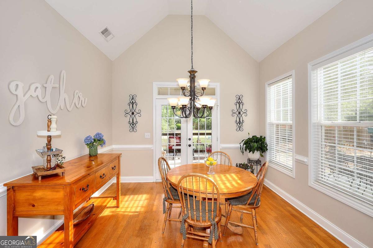 2385 Amberbrook Lane Grayson, GA 30017 - Photo 13 of 57 a dining room with furniture a chandelier and wooden floor