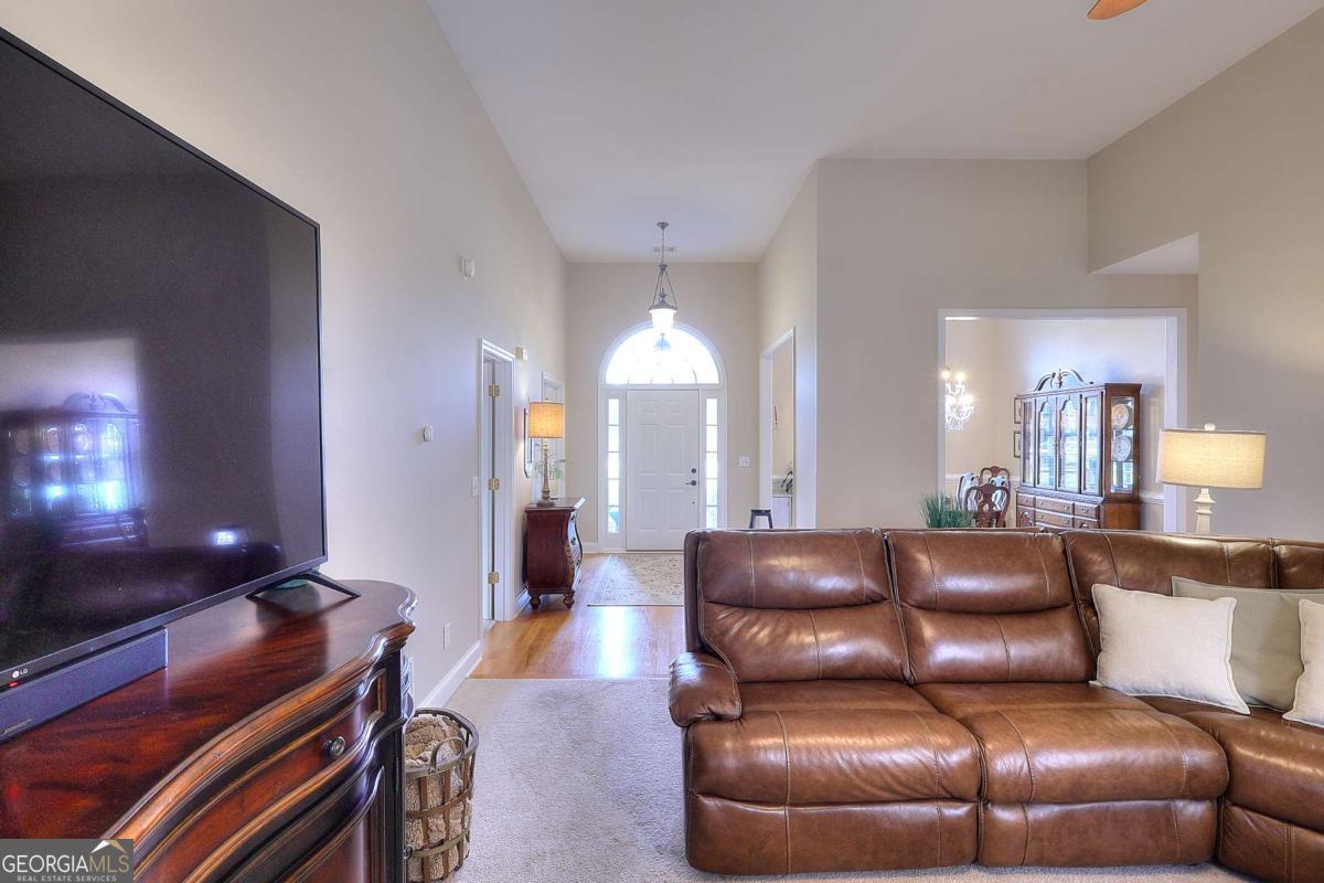 2385 Amberbrook Lane Grayson, GA 30017 - Photo 18 of 57 a living room with furniture and a chandelier